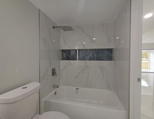 bathroom featuring toilet and tiled shower / bath