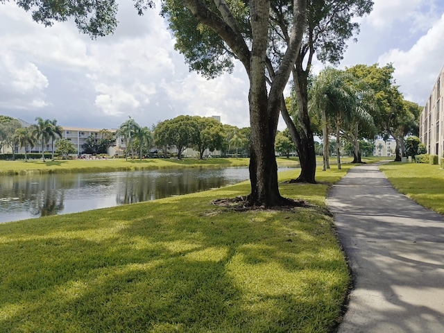 view of community featuring a water view and a yard