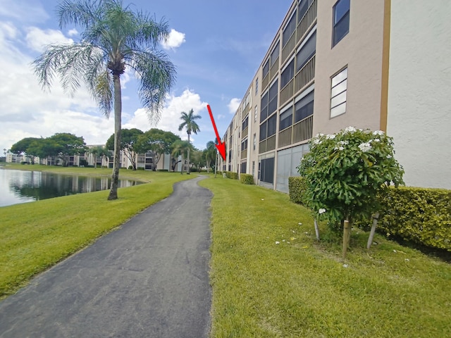 view of property's community with a water view and a yard