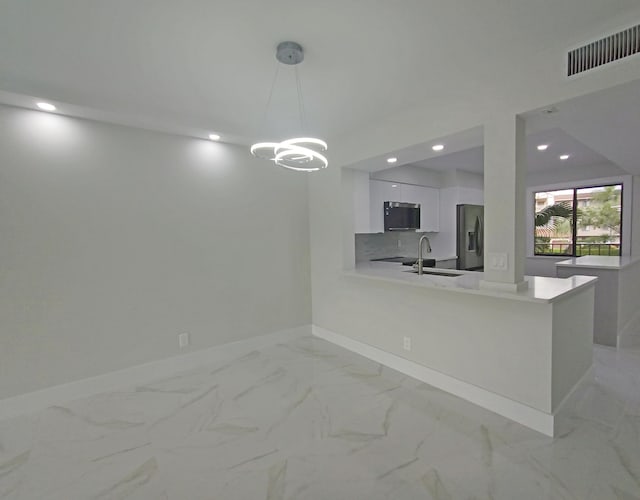 kitchen featuring white cabinets, appliances with stainless steel finishes, sink, kitchen peninsula, and pendant lighting