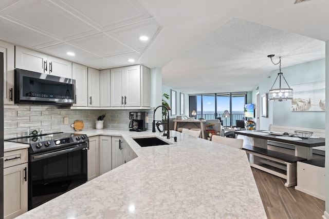 kitchen with dark hardwood / wood-style floors, tasteful backsplash, sink, white cabinets, and black range with electric cooktop