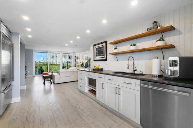 kitchen featuring light wood-type flooring, appliances with stainless steel finishes, sink, and white cabinets