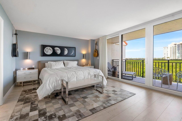 bedroom with baseboards, expansive windows, and access to outside