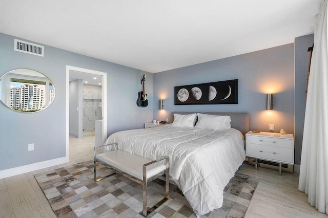 bedroom with connected bathroom, baseboards, visible vents, and light wood-type flooring