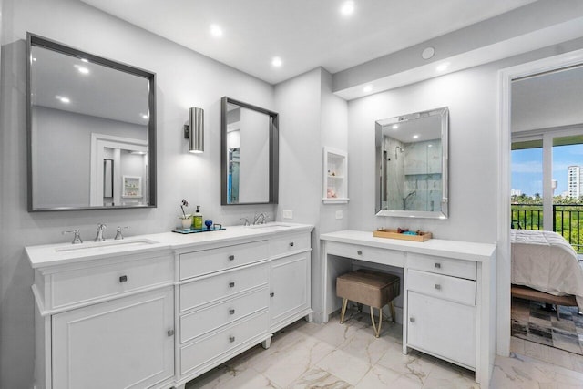 ensuite bathroom featuring marble finish floor, double vanity, recessed lighting, and a sink