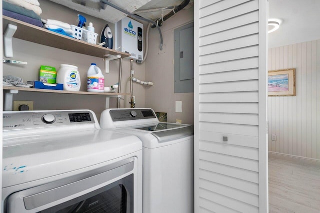 washroom featuring washer and clothes dryer, electric panel, laundry area, and wood finished floors