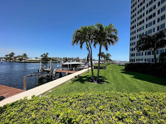 dock area featuring a water view, boat lift, and a yard