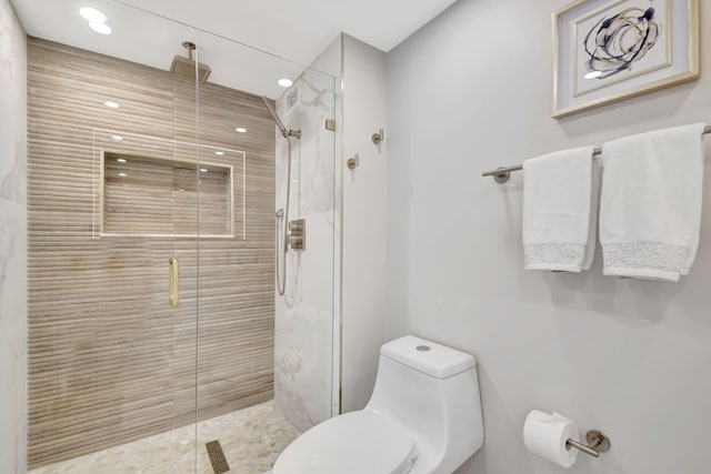 bathroom with toilet and a shower with door