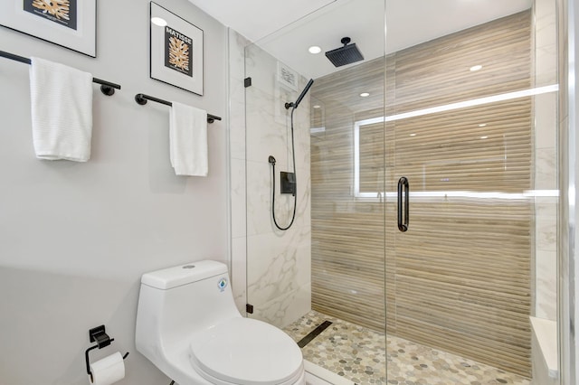 bathroom with toilet and a shower with door