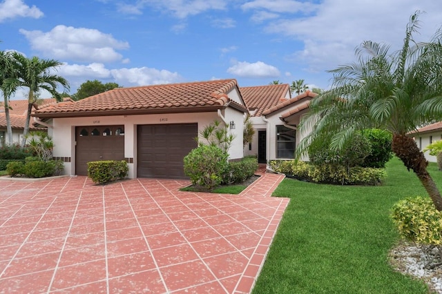 mediterranean / spanish-style house featuring a front yard and a garage