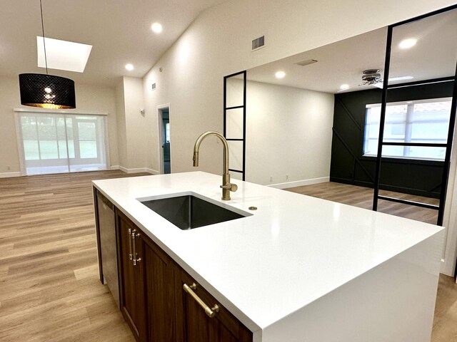 interior space featuring light hardwood / wood-style flooring and lofted ceiling with skylight