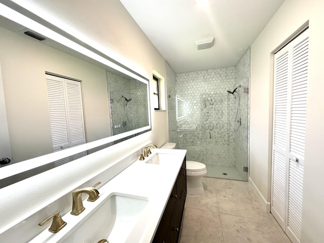 bathroom featuring tile patterned floors, walk in shower, toilet, and vanity