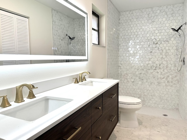 bathroom featuring vanity, toilet, and a tile shower