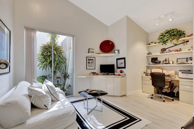 interior space with light hardwood / wood-style flooring, high vaulted ceiling, and rail lighting