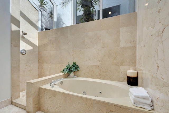 bathroom with tile walls and independent shower and bath