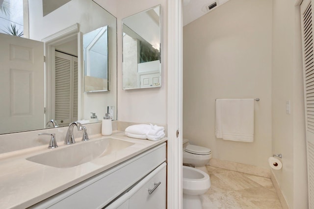 bathroom featuring toilet, a bidet, vanity, and tile patterned floors