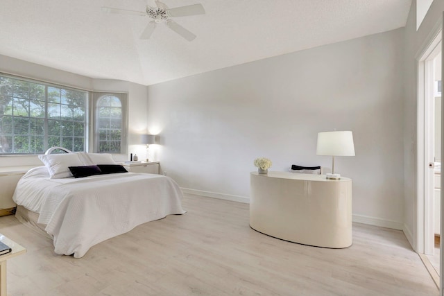 bedroom with ceiling fan, light wood-type flooring, and lofted ceiling