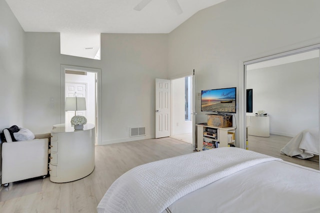 bedroom with light hardwood / wood-style floors, vaulted ceiling, and ceiling fan