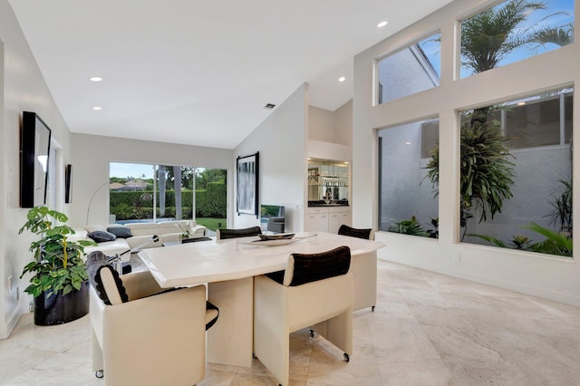 tiled dining space featuring high vaulted ceiling