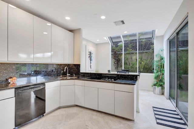 kitchen with sink, dark stone countertops, kitchen peninsula, black dishwasher, and light tile patterned flooring