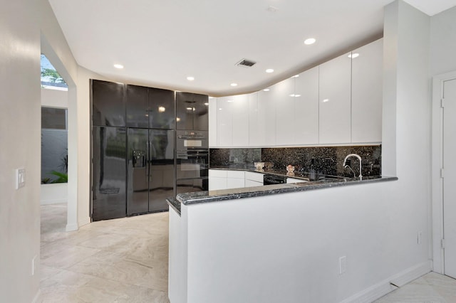 kitchen featuring tasteful backsplash, white cabinets, light tile patterned floors, kitchen peninsula, and dark stone countertops