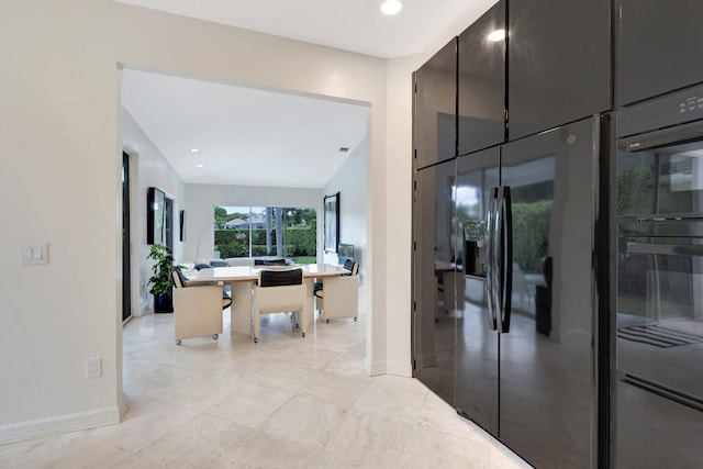 hall featuring vaulted ceiling and light tile patterned floors