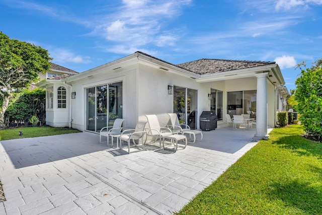 rear view of property with a patio area and a lawn