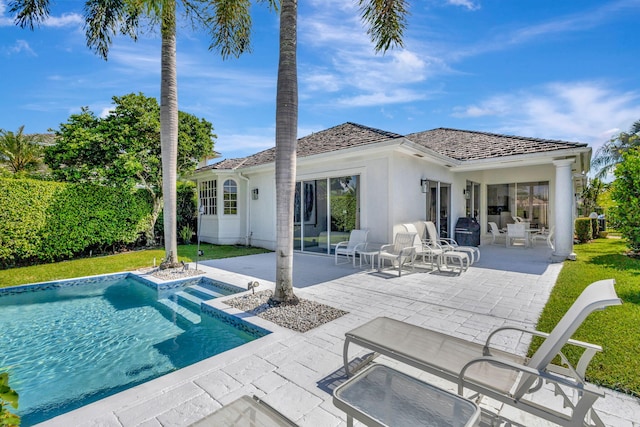 rear view of property featuring a fenced in pool, a patio area, and a yard