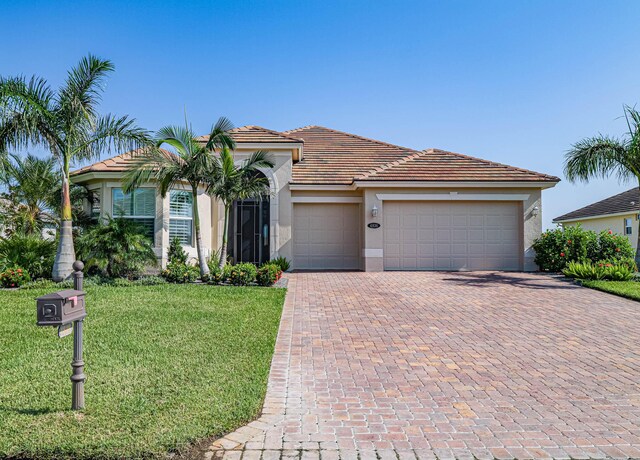 view of front facade with a water view, a garage, and a front yard