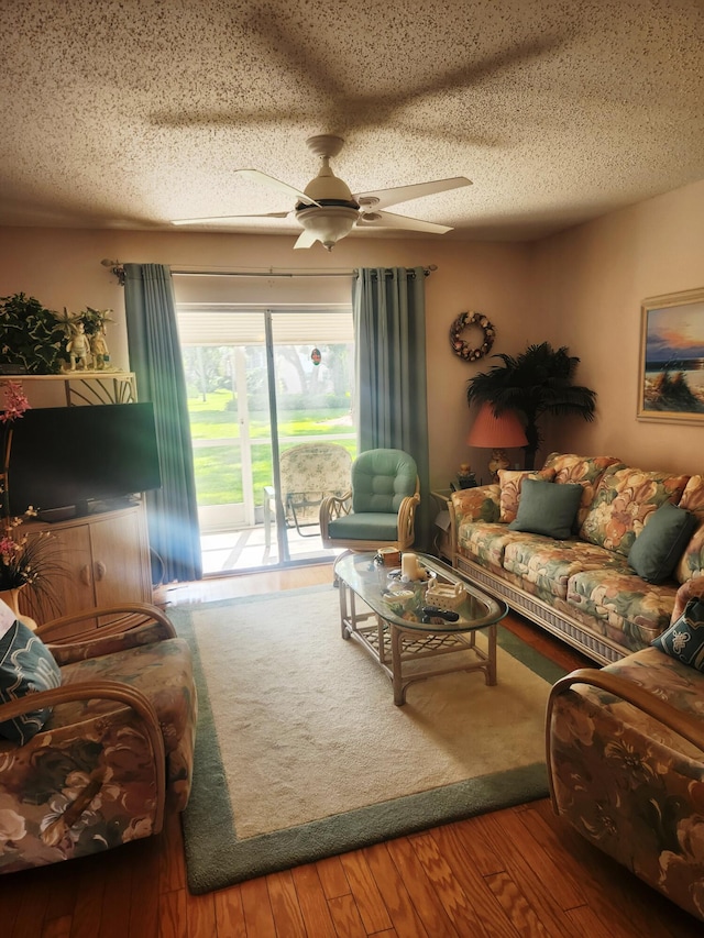 living room with hardwood / wood-style flooring, a textured ceiling, and ceiling fan