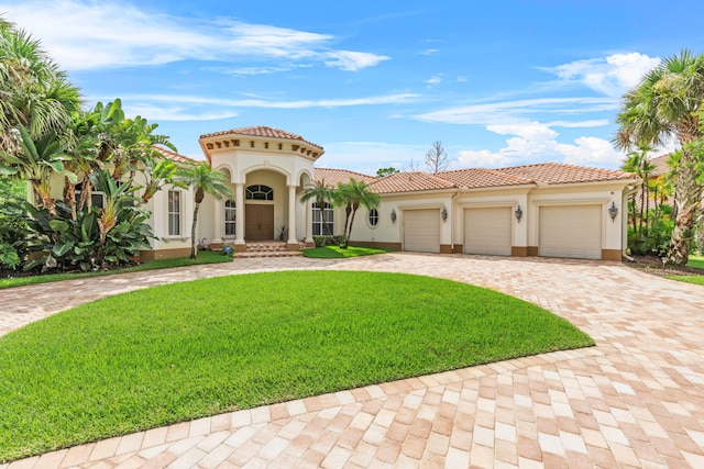 mediterranean / spanish-style house featuring a front yard and a garage