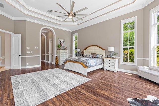 bedroom featuring multiple windows, ceiling fan, a raised ceiling, and hardwood / wood-style flooring