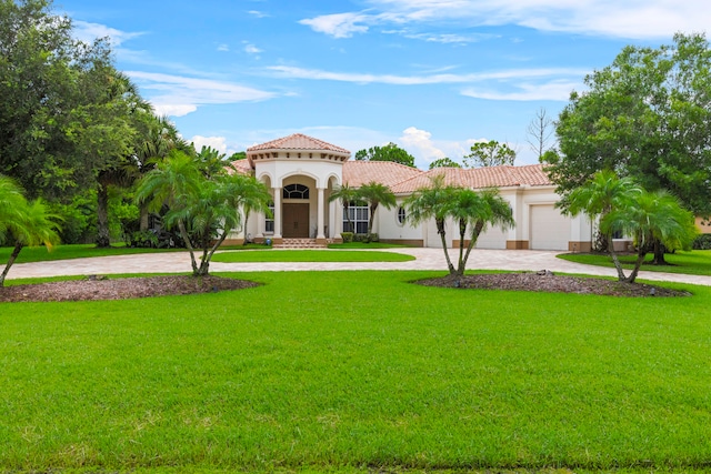 mediterranean / spanish-style house featuring a garage and a front yard