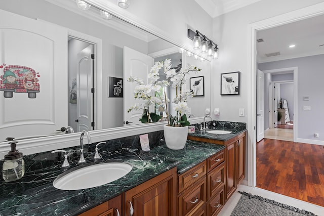 bathroom featuring dual vanity, hardwood / wood-style flooring, and ornamental molding