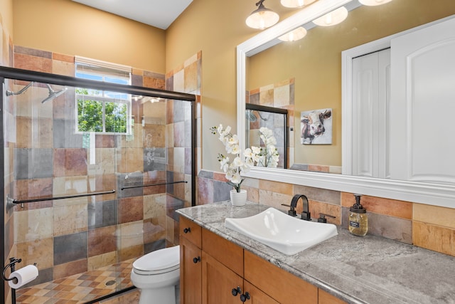 bathroom featuring an enclosed shower, backsplash, vanity, and toilet