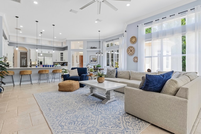 tiled living room with ceiling fan and crown molding