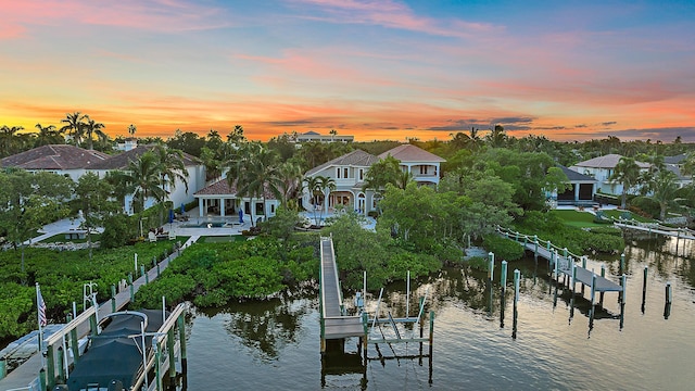 dock area with a water view, boat lift, a residential view, and fence