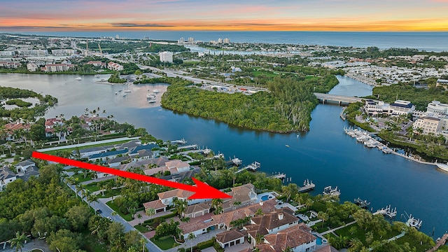 aerial view at dusk featuring a water view