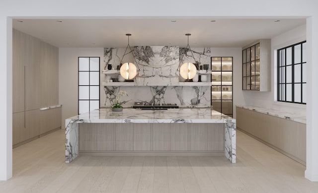 kitchen with light stone countertops, light hardwood / wood-style floors, and tasteful backsplash