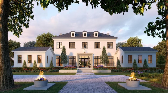 view of front of house with an outdoor fire pit, a front yard, and stucco siding