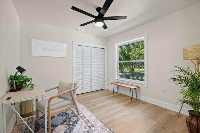 office with light hardwood / wood-style flooring and ceiling fan