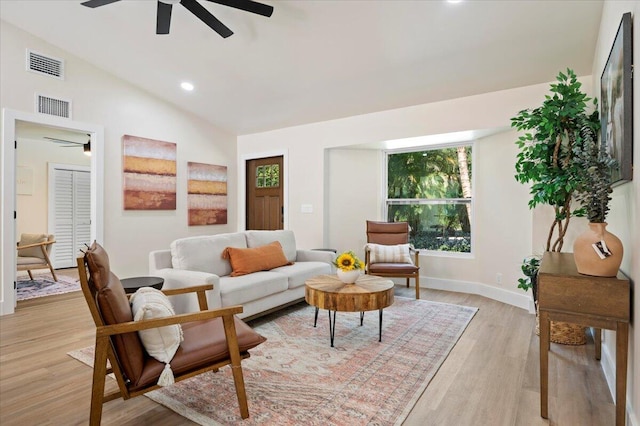 living room featuring light wood-type flooring, ceiling fan, and vaulted ceiling