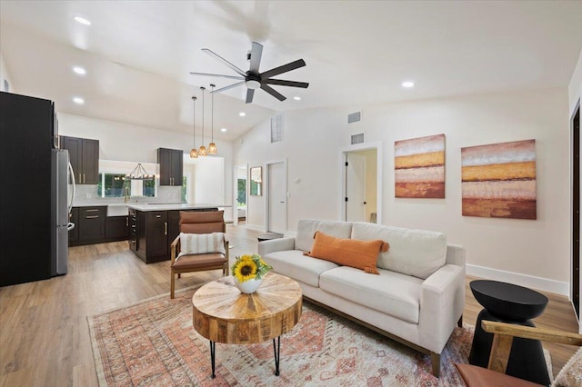 living room featuring light wood-type flooring, high vaulted ceiling, and ceiling fan