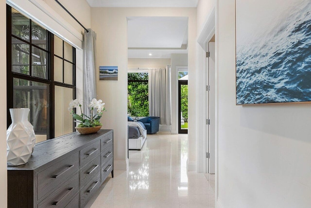 hall featuring baseboards and light tile patterned flooring