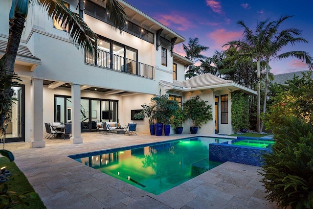 pool at dusk with a patio