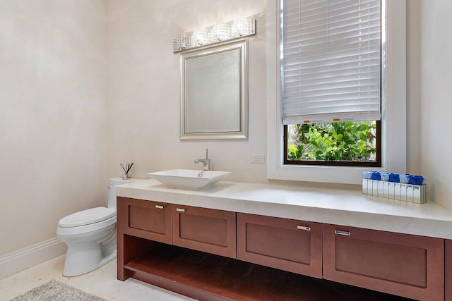 bathroom featuring vanity, toilet, and baseboards