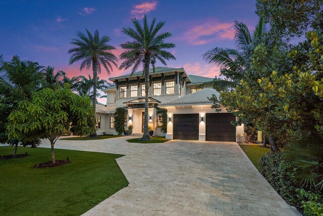 view of front of property with a garage and a yard