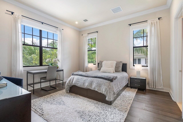 bedroom with baseboards, dark wood-style flooring, crown molding, and visible vents