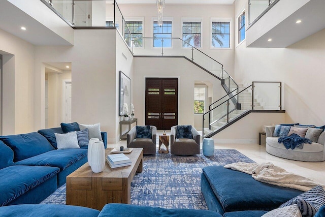 living room featuring a towering ceiling, french doors, recessed lighting, stairway, and baseboards