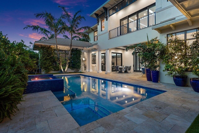 outdoor pool with a jacuzzi and a patio area